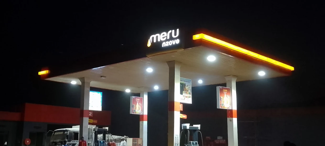 Illuminated Meru Nzove fuel-station canopy signage at night, fabricated and installed by Basai